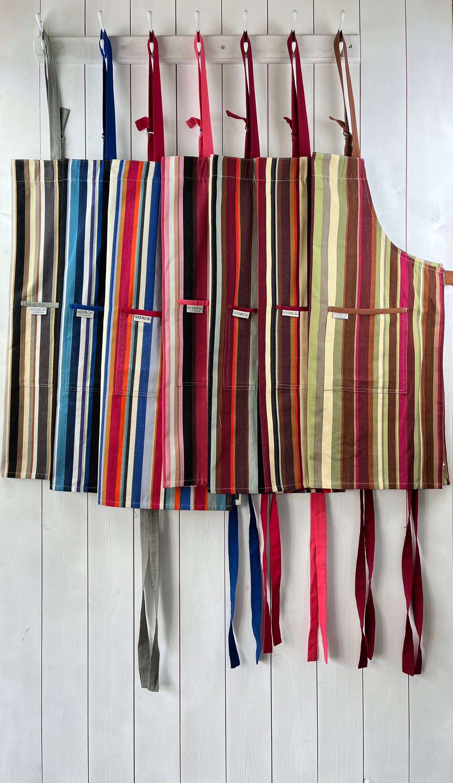 a selection of vibrant and modern striped cotton aprons from sterck & co.