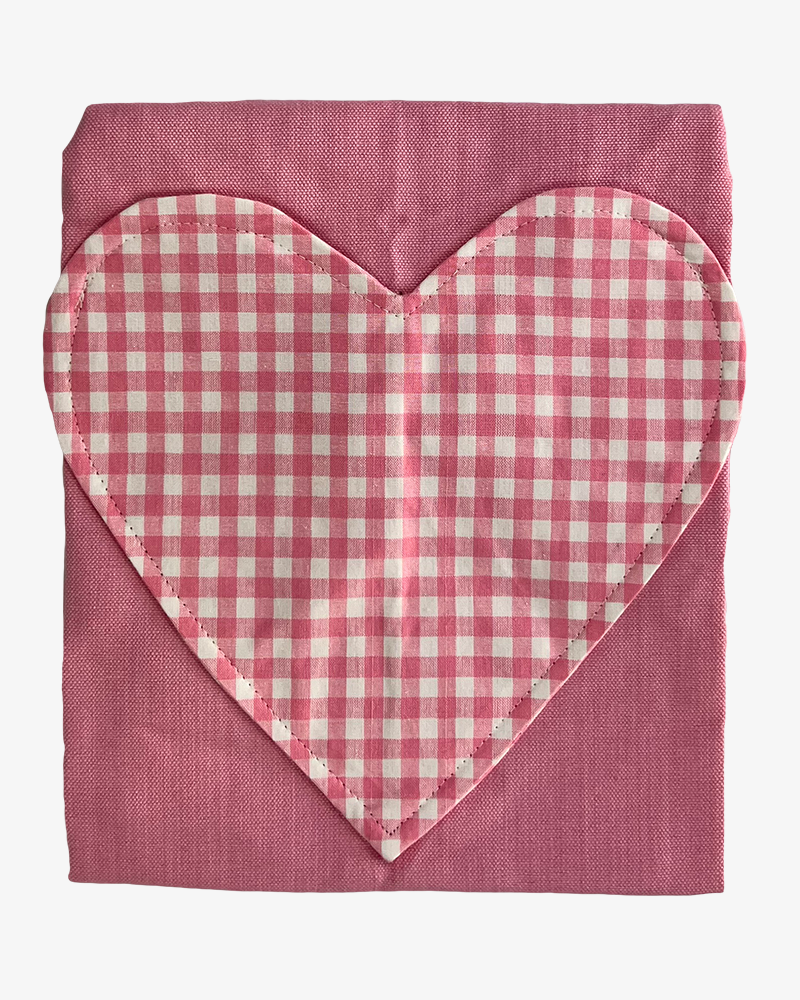 close up of a child's apron with a gingham heart detailing front pocket. made from a durable pure cotton branded sterck.