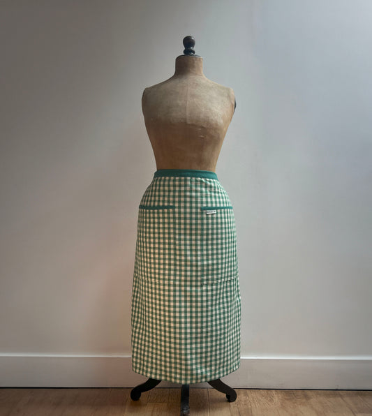 A classic green gingham half apron from Sterck and Co.  modelled here by a vintage mannequin.