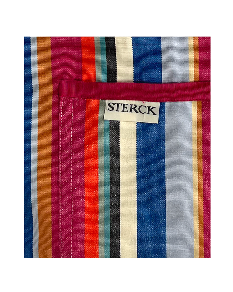 a modern stripy apron with double front pockets, red ties and adjustable neck strap. waikiki from sterck & co. close up of fabric and pocket detailing.