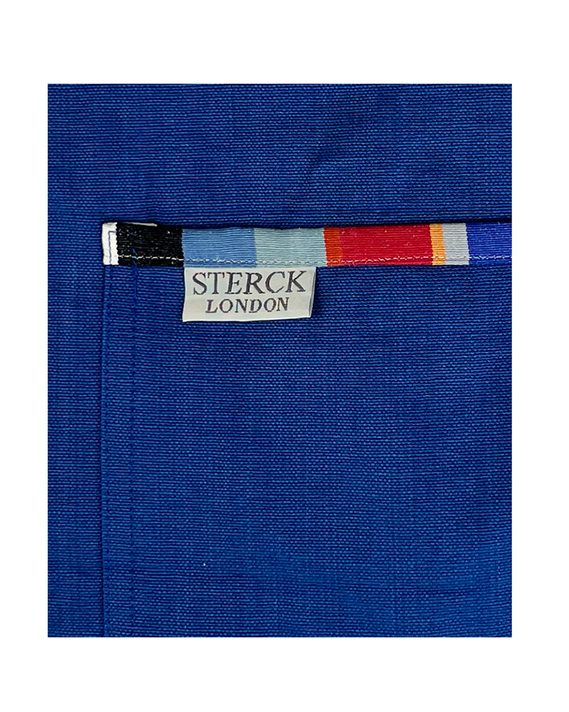 waikiki royal blue apron. bold blue background with stripy detailing. 100% cotton, double front pockets and adjustable neck strap. sterck & co. close up of fabric and pocket detail.