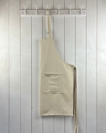 Alabaster white cotton apron with double front pockets and adjustable neck strap. Sterck & Co.