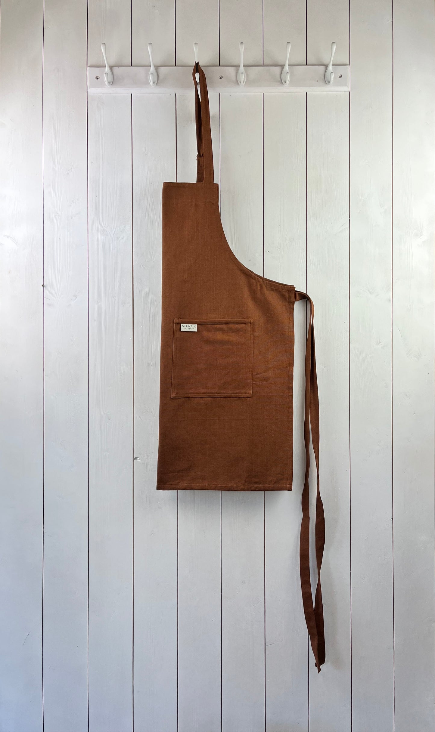 chocolate brown cotton apron with double front pockets and adjustable neck strap. sterck & co.