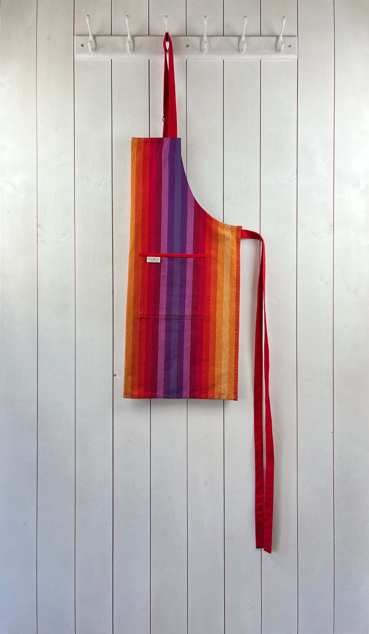 chihuahua rainbow striped cotton apron with double front pockets, red ties and adjustable neck strap. sterck & co.