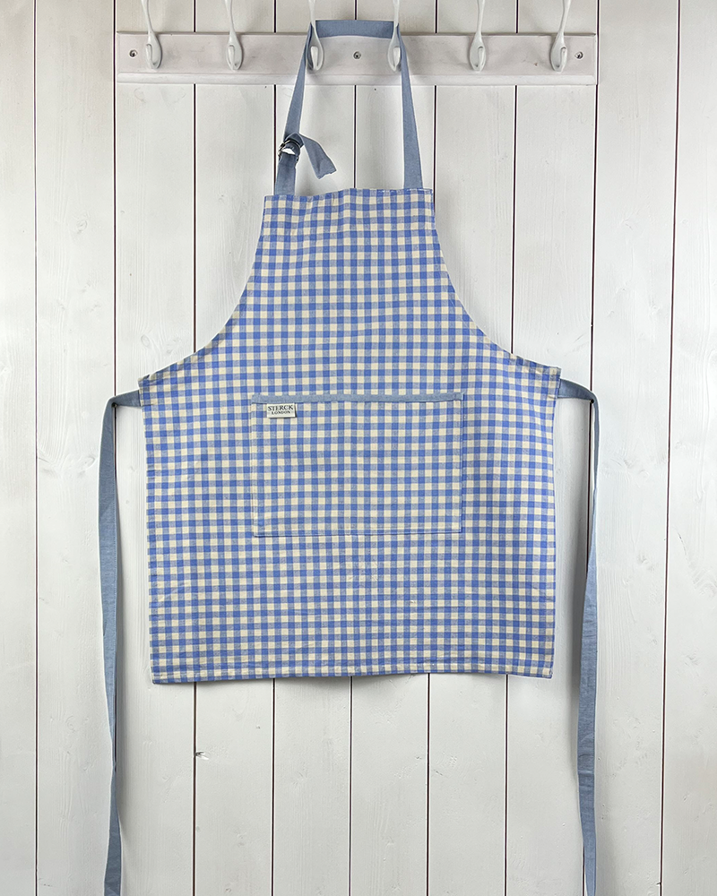 blue gingham apron for children with large front pocket and adjustable neck strap. sterck & co.