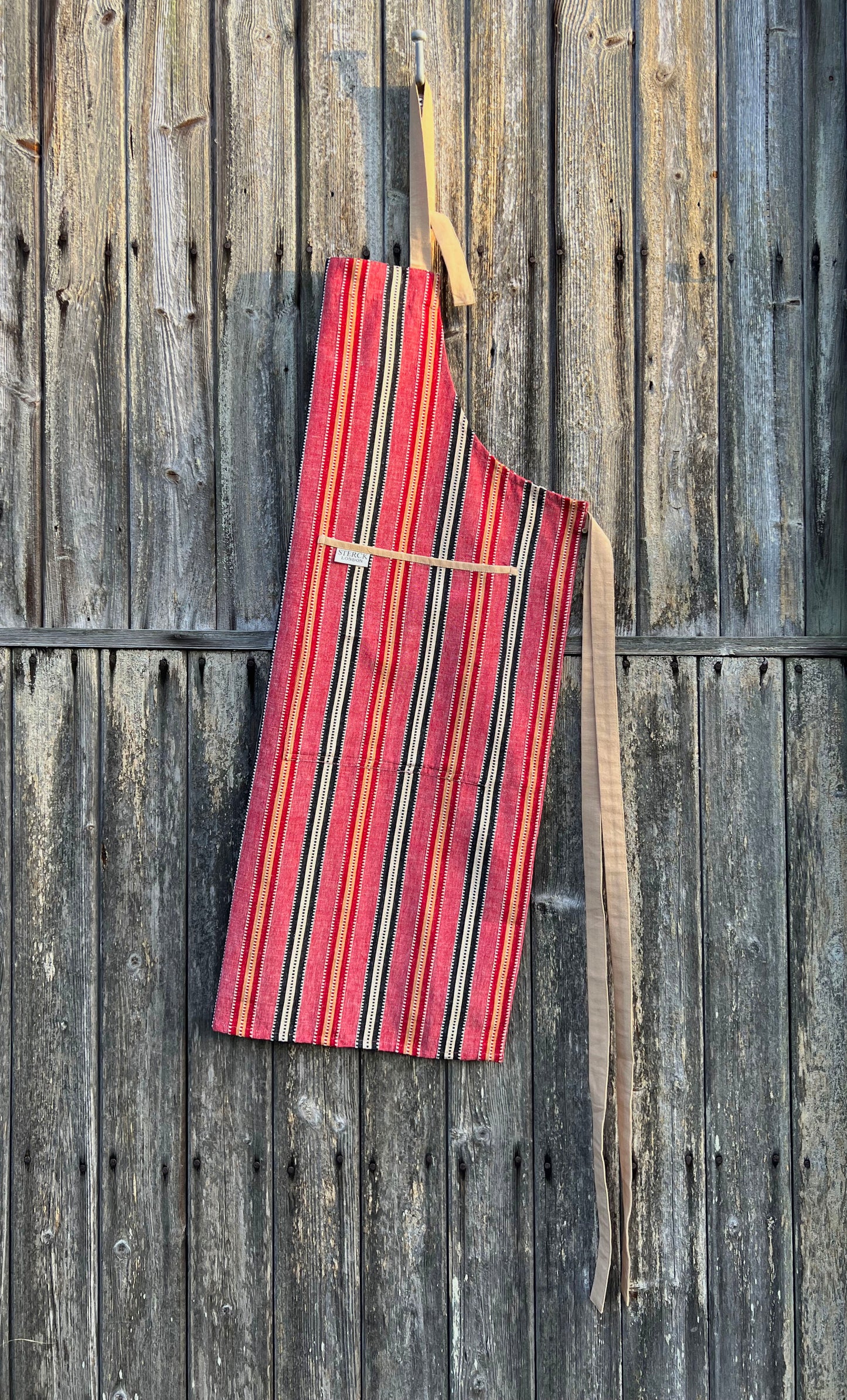 chimichanga dusky red striped cotton apron with double front pockets and adjustable neck strap. sterck & co. rustic.