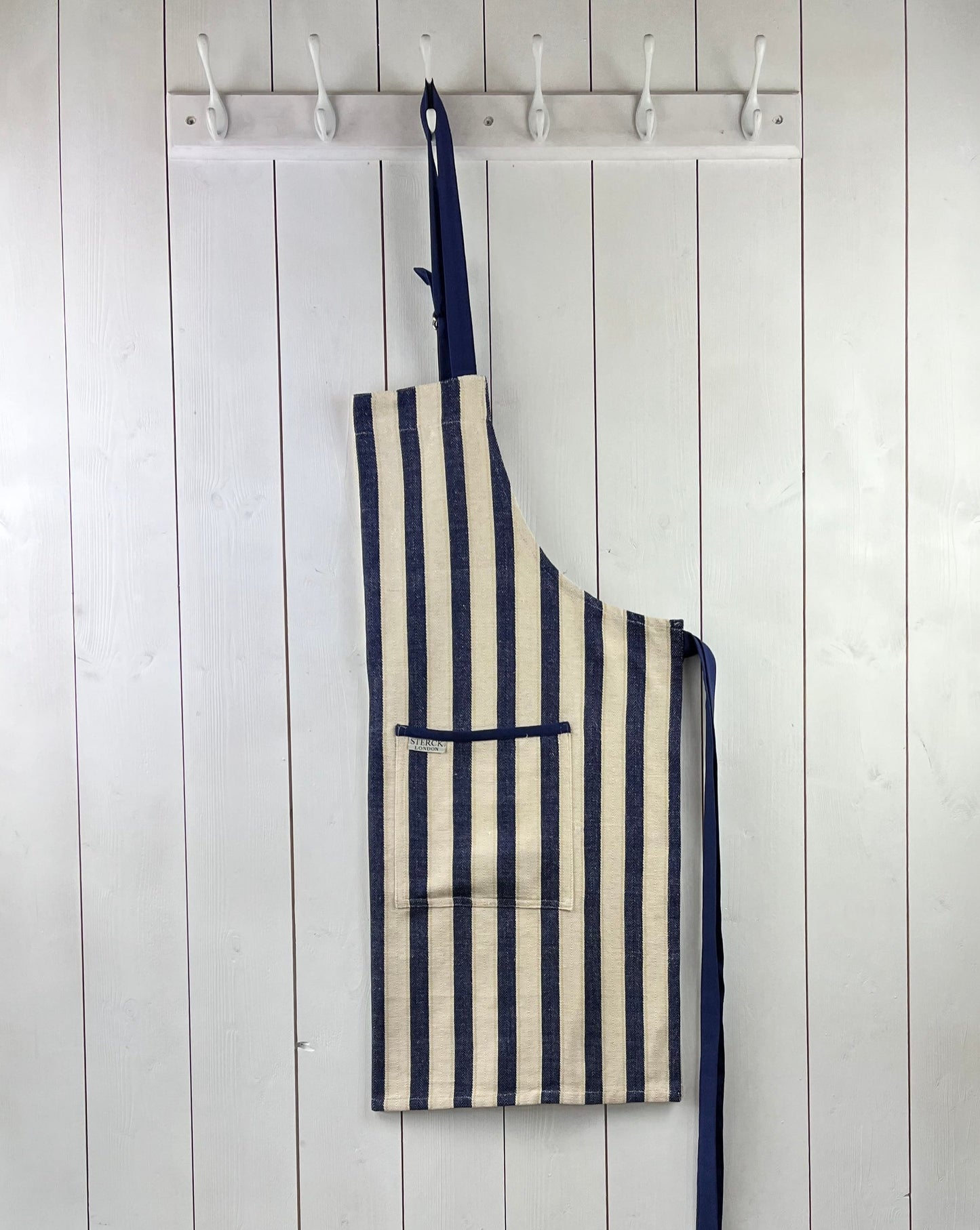 a classic wide striped cotton apron with double front pockets and adjustable neck tie. from sterck & co.