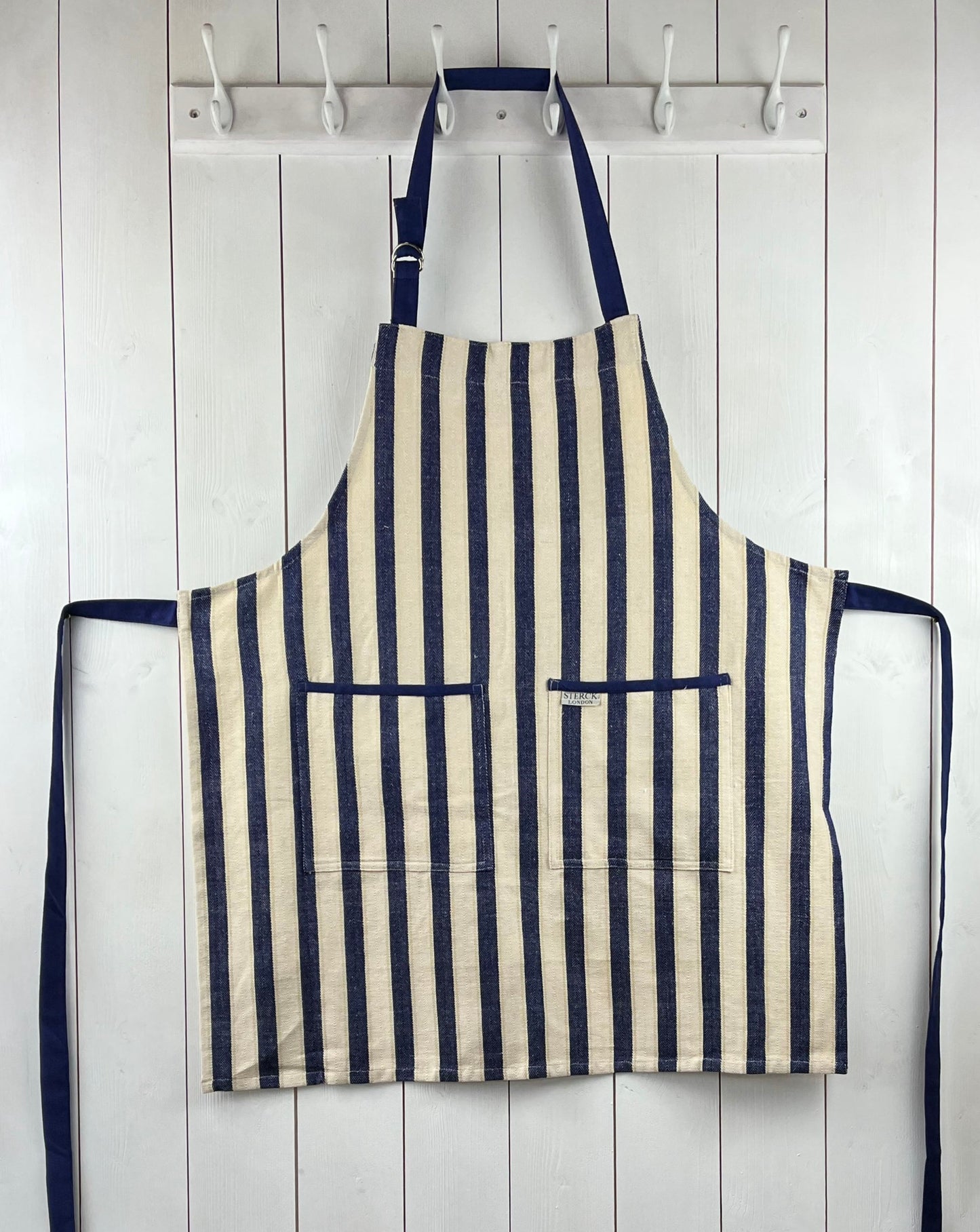 a classic wide striped cotton apron with double front pockets and adjustable neck tie. from sterck & co.