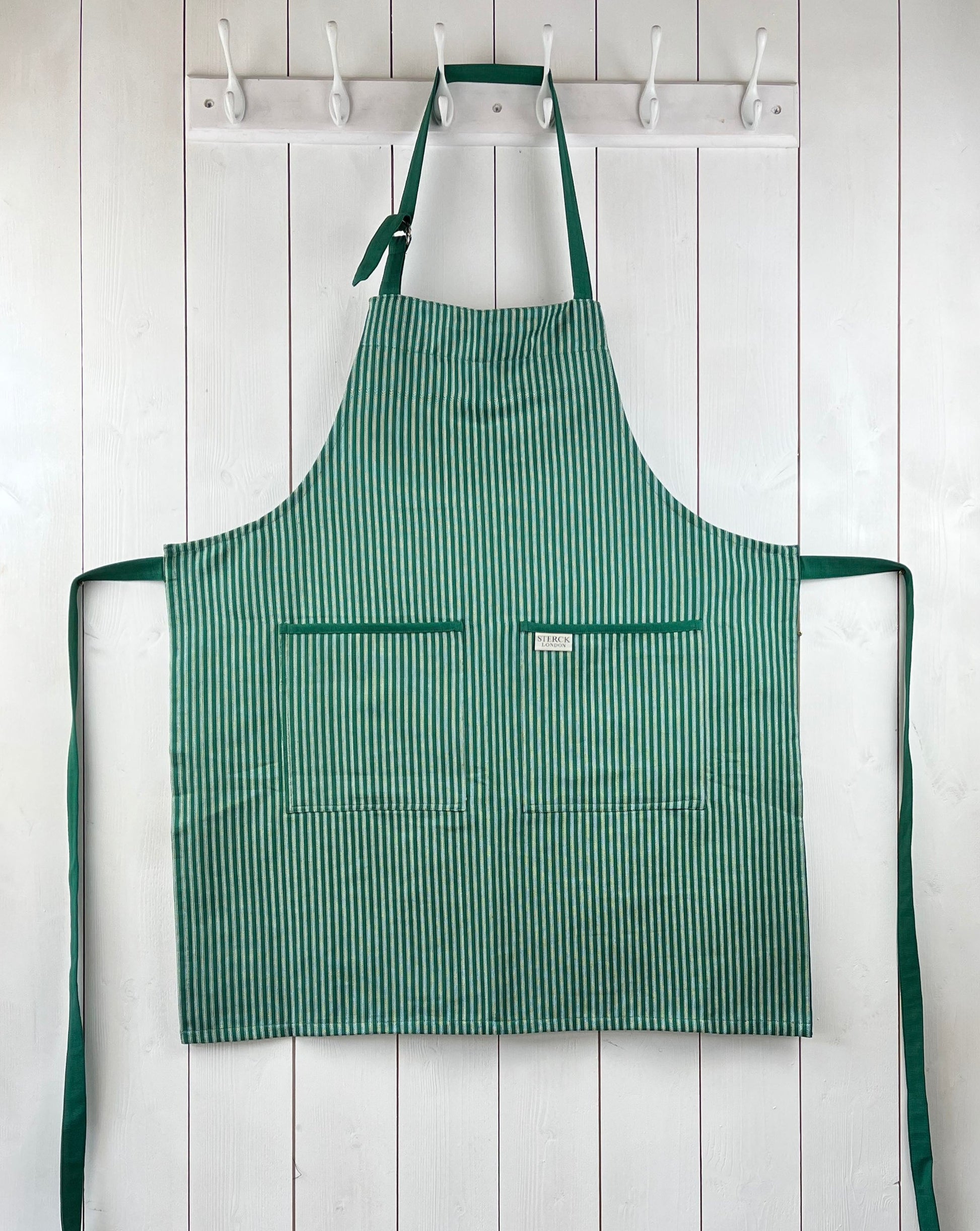 Green striped cotton apron with double front pockets, green ties and adjustable neck strap. Sterck & Co. Drum green.