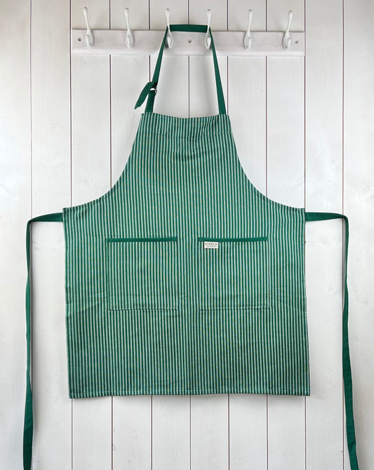 Green striped cotton apron with double front pockets, green ties and adjustable neck strap. Sterck & Co. Drum green.