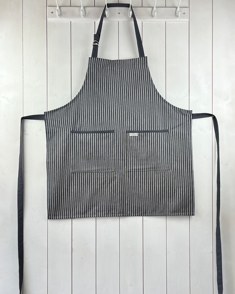 grey striped cotton apron with double front pockets, grey ties and adjustable neck strap. sterck & co. drum grey.