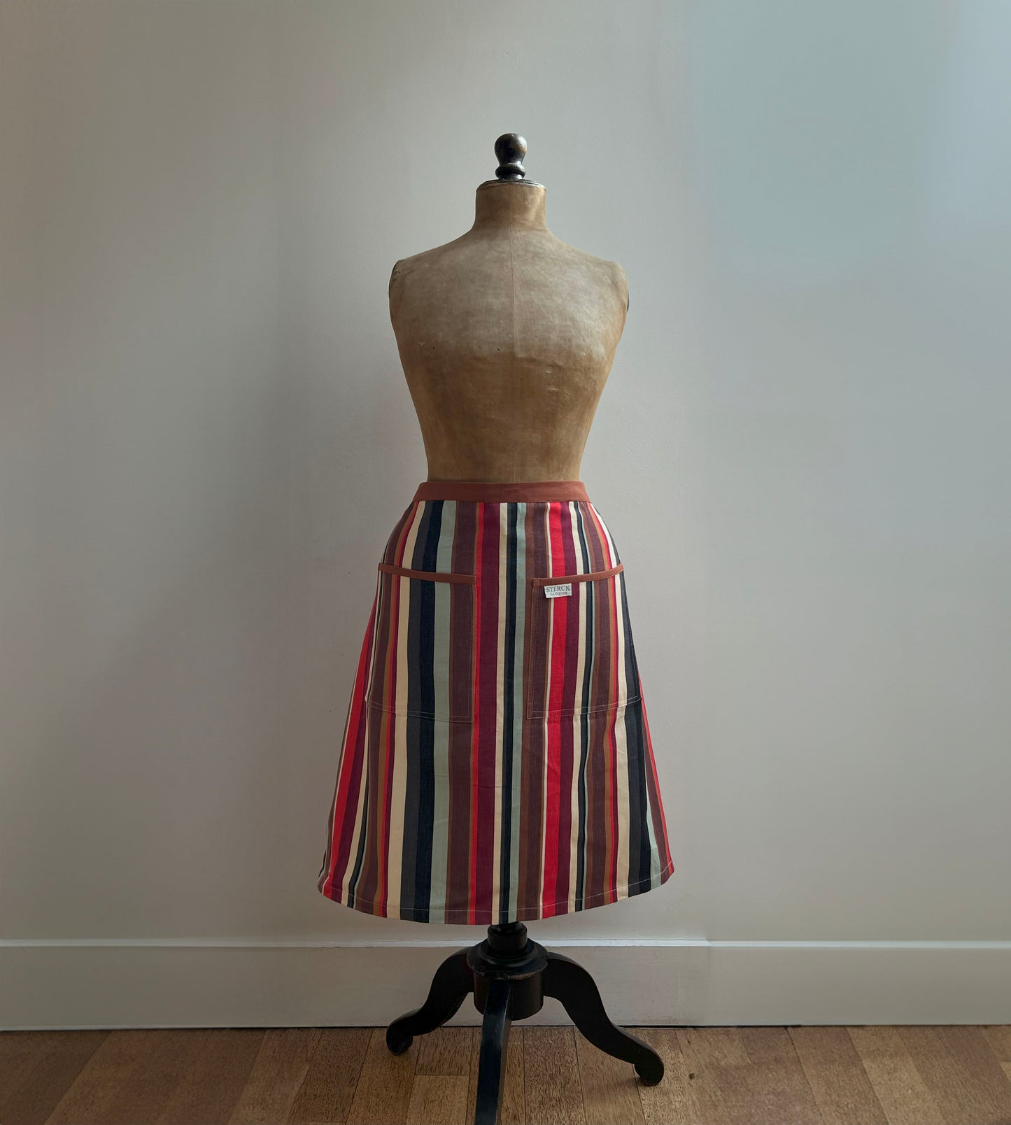 a modern, stripy half apron with russet tones.