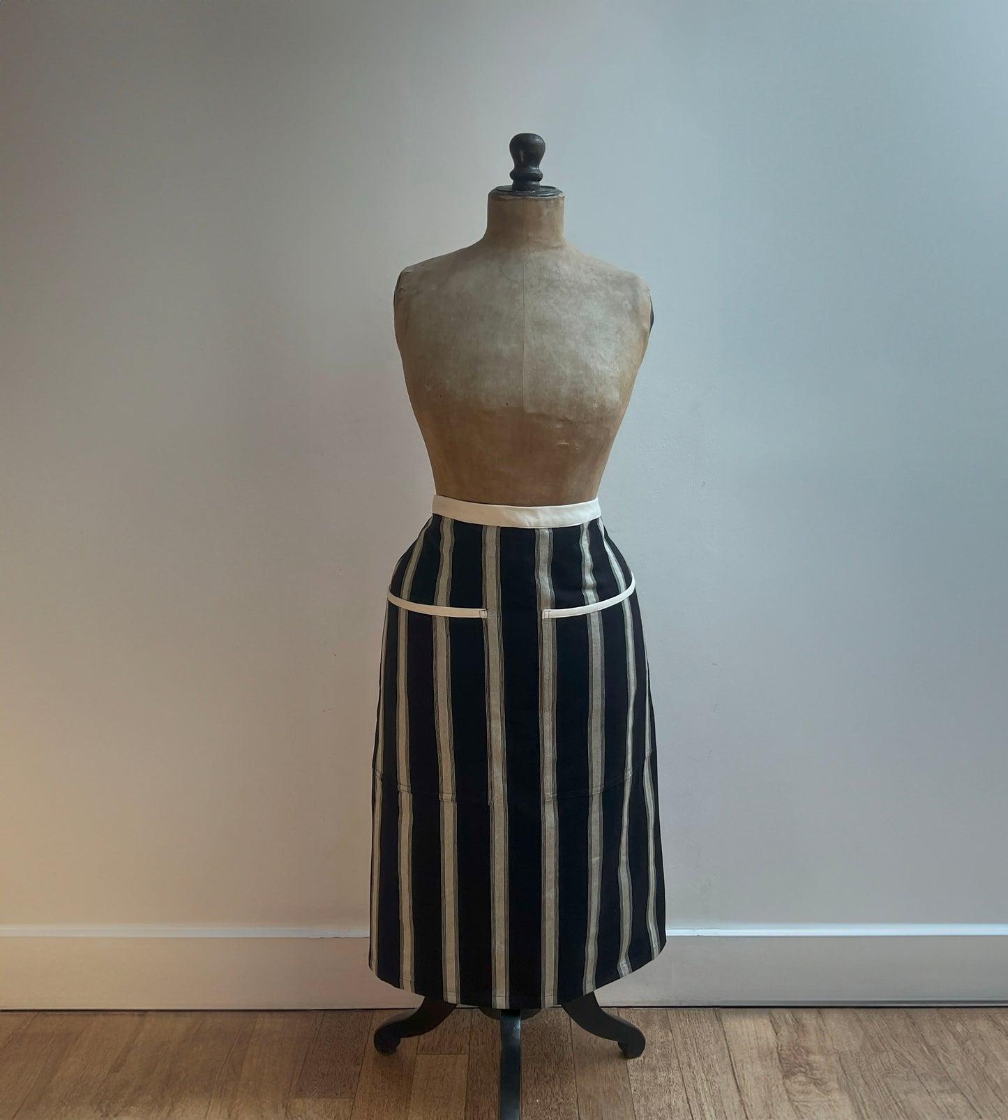 a classically stiped black and cream cotton half apron from sterck & co.  modelled here by a vintage mannequin.