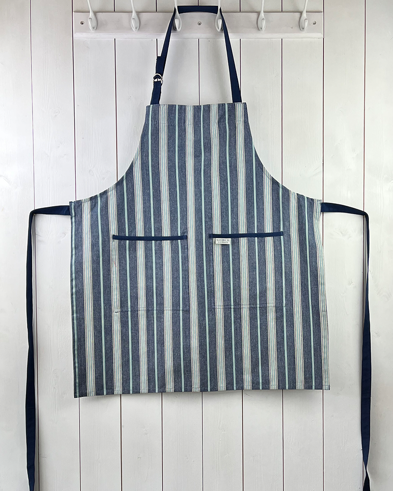 a classic blue striped cotton apron with double front pockets, blue ties and adjustable neck strap. sterck & co.