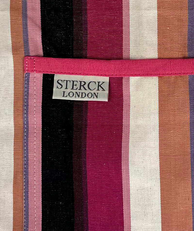 a modern and stylish pink stripy cotton apron with double front pockets and adjustable neck strap. close up of fabric and pocket detailing.