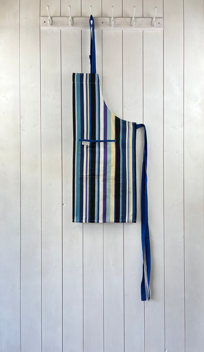 A modern and stylish blue stripy apron with double front pockets, blue ties and adjustable neck strap. 100% cotton. Sterck & Co.