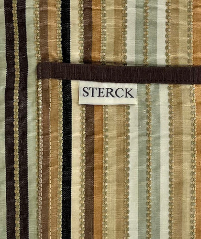 Stripy cotton apron with double front pockets, adjustable neck strap, and brown detailing. Close up of fabric and pocket detailing.
