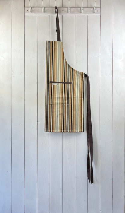 Stripy cotton apron with double front pockets, adjustable neck strap, and brown detailing.