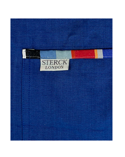 Waikiki Royal Blue Apron. Bold blue background with stripy detailing. 100% cotton, double front pockets and adjustable neck strap. Sterck & Co. Close up of fabric and pocket detail.